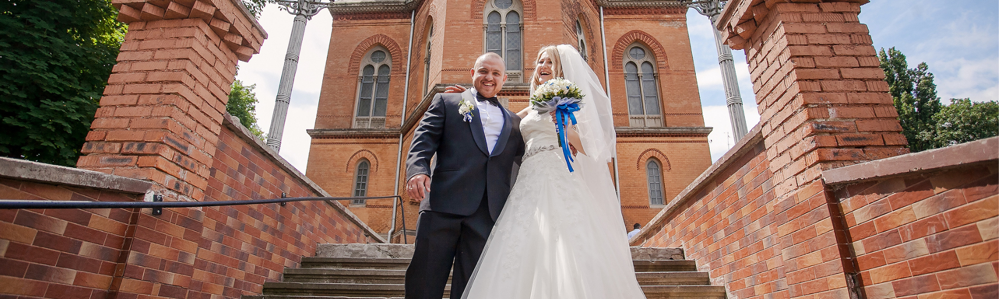 Newly wedded couple standing in front of a church 