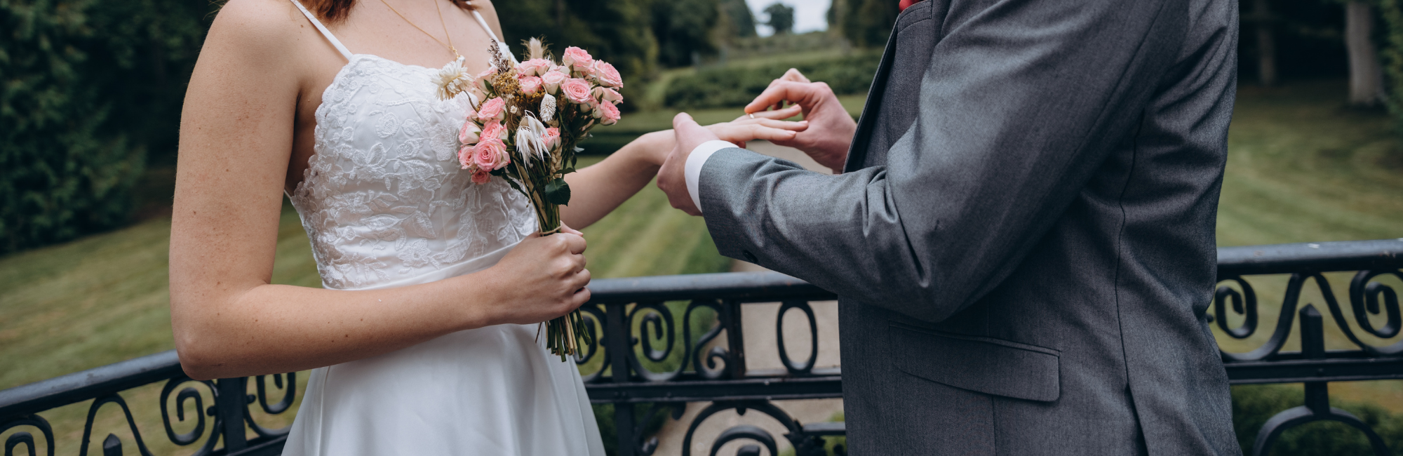 groom placing a wedding ring on bride's finger